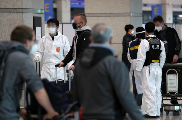 국내에서 코로나19의 새로운 변이 바이러스 '오미크론' 확진자가 확인된 2일 인천국제공항 제1여객터미널에서 해외 입국자들이 임시 생활시설로 가기 위해 질병관리본부 직원의 안내를 받고 있다. 사진=뉴시스