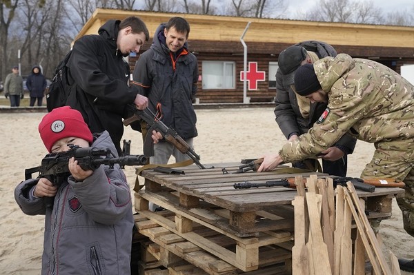 20일(현지시간) 우크라이나 키예프에서 한 교관이 우크라이나 극우 단체회원들에게 AK47 소총에 관해 설명하는 동안 한 소년이 소총을 들고 놀고 있다. 사진=뉴시스