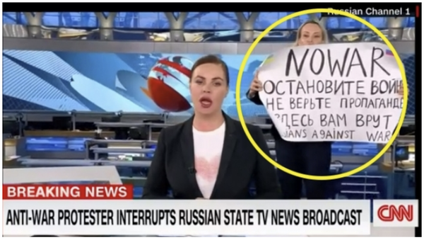 러시아 국영 채널1 TV의 직원 마리아 오브샤니코바(오른쪽)가 14일(현지시간) 뉴스 방송 도중 난입해 반전 메시지를 적은 종이를 들어보이고 있다. CNN화면 캡처