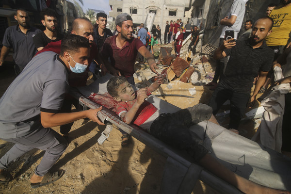 24일(현지시각) 가자지구 라파의 팔레스타인 주민들이 이스라엘의 공습으로 무너진 잔해 속에서 소년을 찾아내 들것으로 옮기고 있다. 2023.10.25.