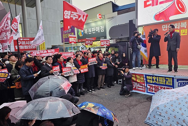 장동혁 굼민의힘 당대표가 25일 구미역 광장에서 열린 민생회복 법치수호 경북 국민대회 연단에 오르자 갑자기 비가내려 취재진이 우산을 공급받아 쓰고 취재를 하고있다. 이날 장 대표는 앞선 대회보다 목소리 톤을 낮추오 차분하게 연설을 진행했다. (사진/장지수 기자)